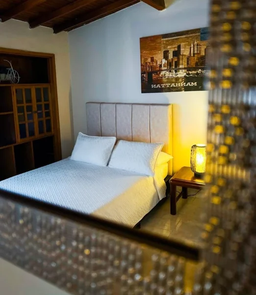 Sala principal de Casa la Morada Medellín — decoración elegante en tonos beige y morado con mobiliario de lino